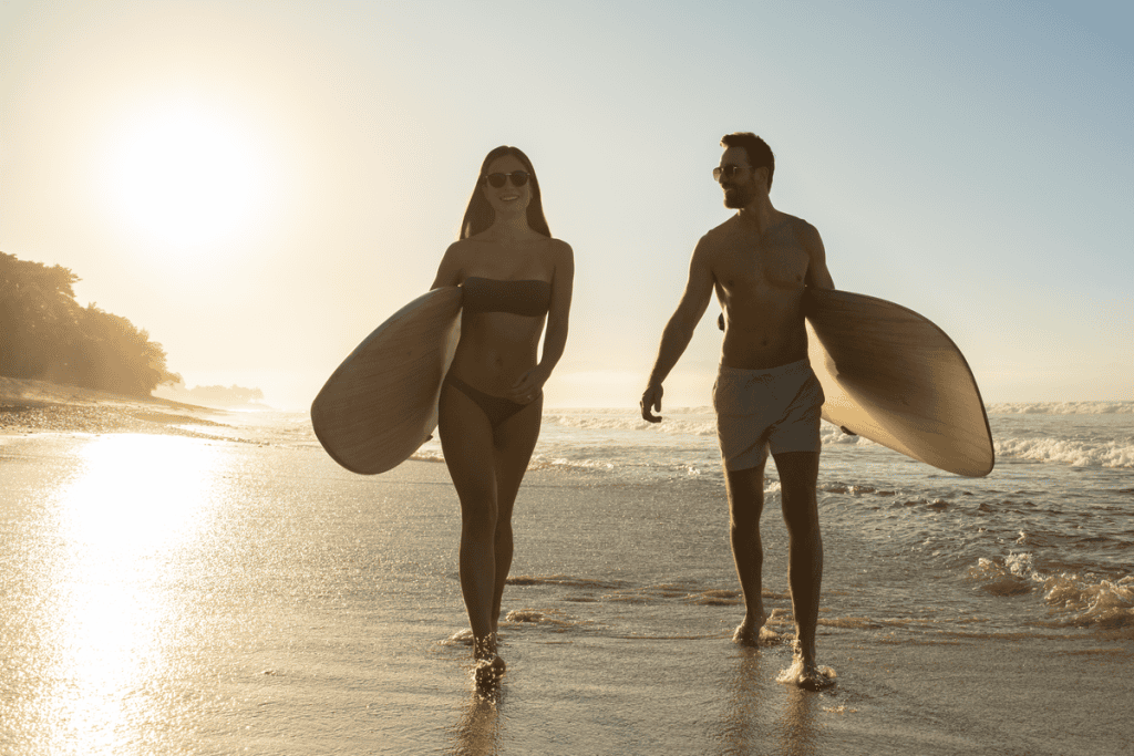 People walking with surfboards on the beach